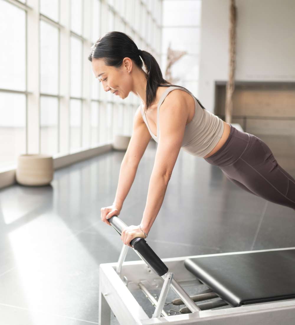 woman using reformer footbar