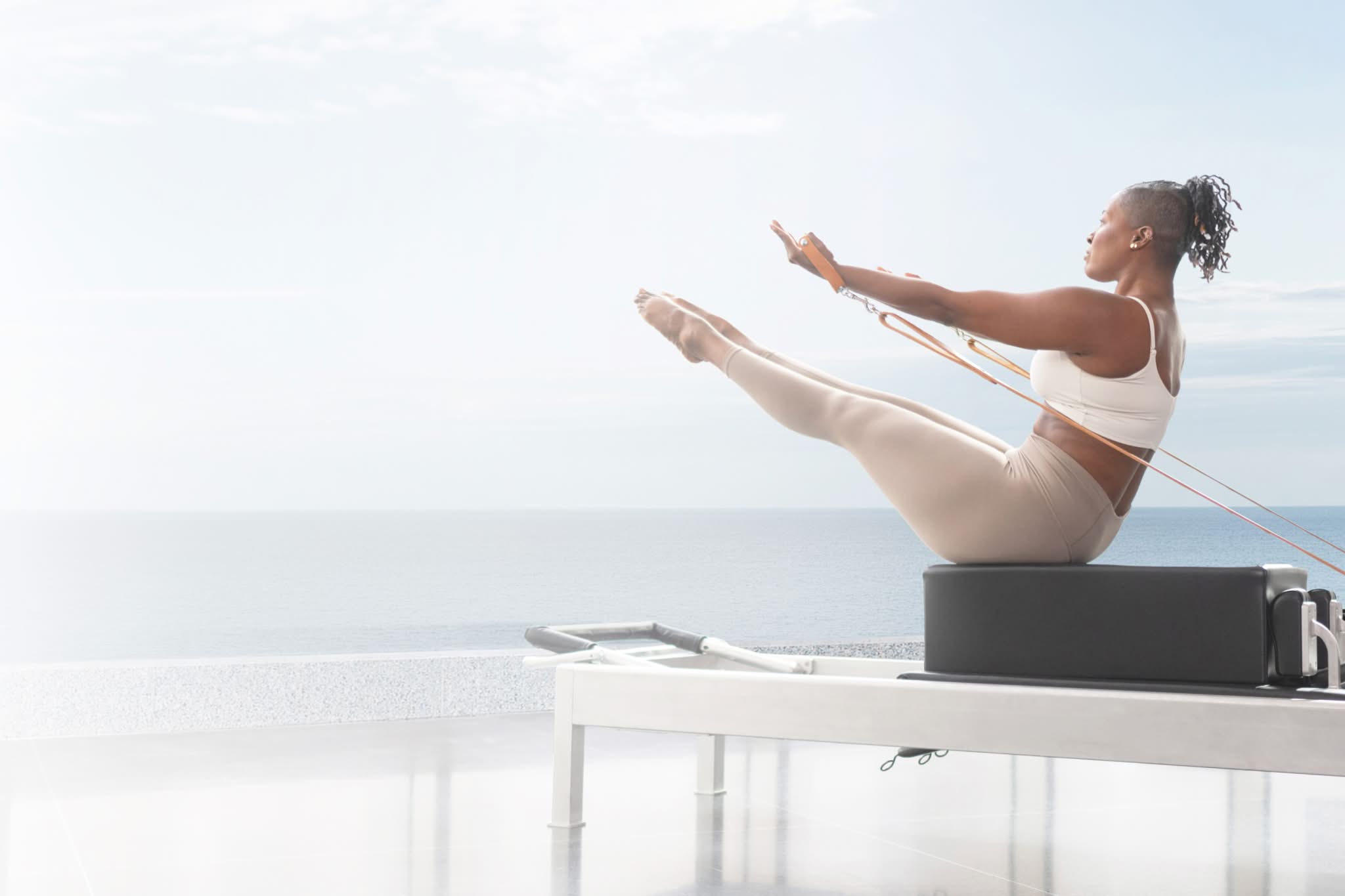 woman by the beach on contrology reformer